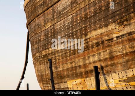 Nahaufnahme von verwitterten Holzschiffsplanken, die mit Holzkeilen besetzt sind, im warmen Sonnenlicht, Gujarat, Mandvi, Indien Stockfoto