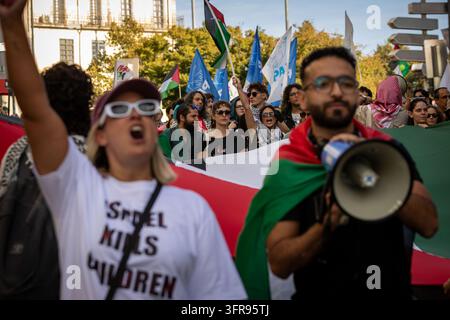 Demonstranten, die palästinensische Flaggen tragen, skandieren Parolen zu Beginn eines Marsches in Solidarität mit Palästina, nachdem sie sich auf der Praça dos Poveiros in Porto versammelt haben. Stockfoto