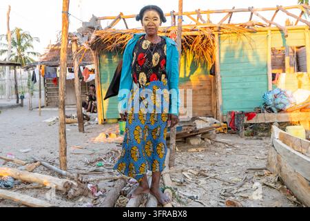 Vezo-Frau, die eine traditionelle Gesichtsmaske trägt, steht zwischen Holzbootrahmen im Dorf, Menabe, Belo sur Mer, Madagaskar Stockfoto