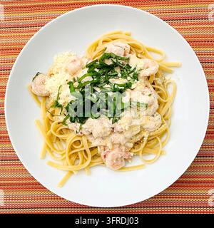 Frische Garnelen auf Linguini mit Weißweinrahmsoße, garniert mit wildem Knoblauch und Parmesan Stockfoto