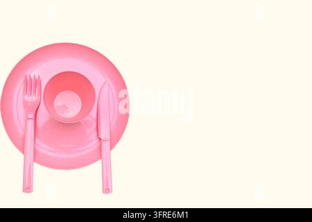 Stellen, legen oder stellen Sie etwas an einem bestimmten Ort oder in einer bestimmten Position ab. Rosa Plastik-Campinglöffel und -Gabeln auf weißem Hintergrund isoliert Stockfoto