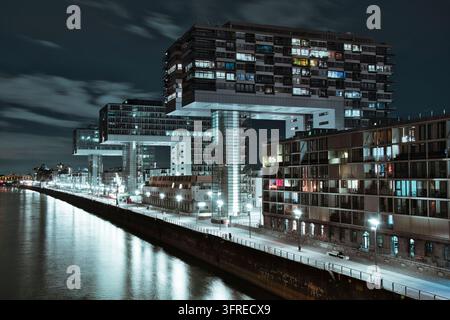 Luftaufnahme von beleuchteten Kranhäusern am Kanal im Zollhafen in Köln bei Nacht Stockfoto