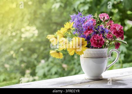 Helles Sommerbouquet aus bunten Blumen auf der Fensterbank. Tonwert Stockfoto