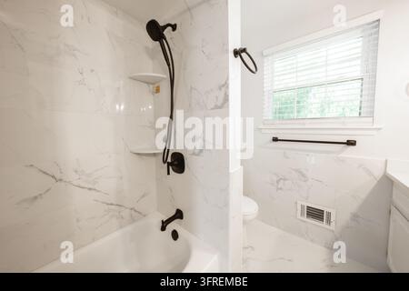 älteres Haus hat Badezimmerduschenrenovierung mit neuen Keramikfliesen und Armaturen Stockfoto