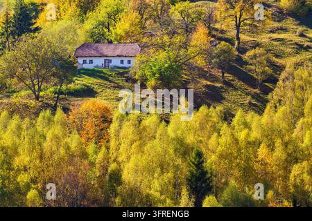 Ein traditionelles ländliches Berghaus auf einem grasbewachsenen Hügel im Dorf Măgura, Rumänien. Stockfoto