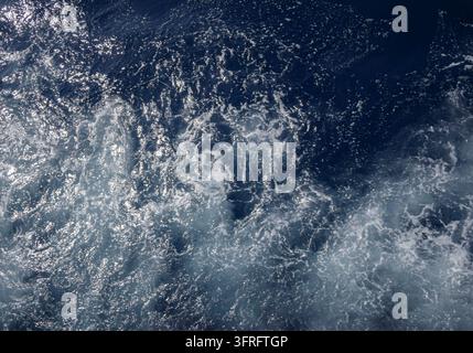 Ozeanwellen-Schaum auf tiefblauem Wasser als Texturrückgrund Stockfoto