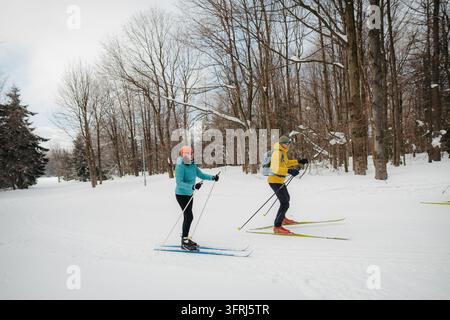 Aktives reifes Paar geht gemeinsam Langlauf im verschneiten Wald. Stockfoto
