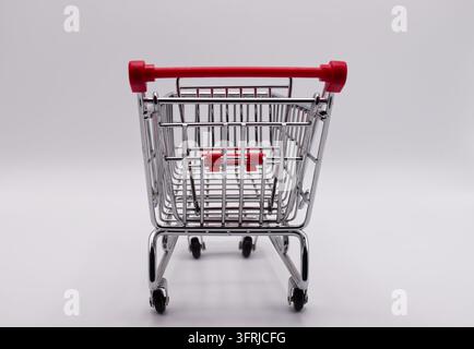 Leerer Miniatur-Einkaufswagen isoliert auf weißem Hintergrund, Rückansicht-Perspektive. Stockfoto