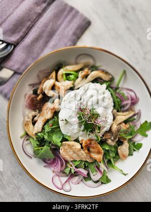 Grüner Salat mit Hühnchen und Pilzen in einer Schüssel auf einem Tisch Stockfoto