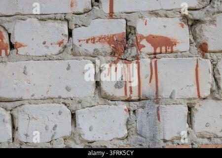 Alte weiße Ziegelwandtextur mit rotbraunen Farbtropfen und Tropfenflecken. Gealterte raue Mauerfläche Nahaufnahme-Hintergrund für urban, vintage, grunge, a Stockfoto