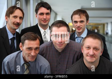 Eine Gruppe von Männern posiert für ein Foto, alle tragen Anzüge und Krawatten. Die Szene ist professionell und formell Stockfoto