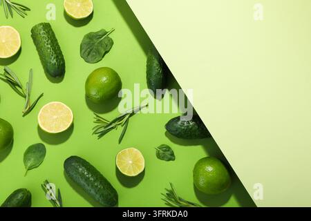 Flat Lay mit Gurken, Limetten, Basilikum und Rosmarin auf zweifarbigem Hintergrund Stockfoto