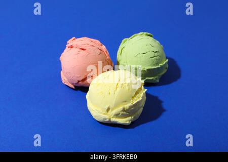 Drei Eiscremebällchen auf blauem Hintergrund Stockfoto