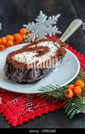 Geschnittene hausgemachte Weihnachts-Schokoladen-Rolle auf einer schönen Spitzenserviette Stockfoto