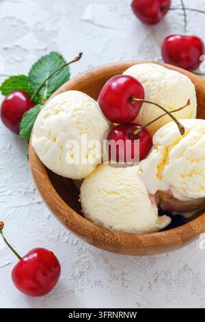 Schale mit Eiscreme und süßen Kirschen auf einem weißen Betonhintergrund Stockfoto