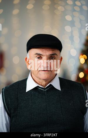 Senior Mann mit flacher Kappe schaut in die Kamera Stockfoto