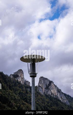 Ein moderner Patioradiator steht hoch aufgerichtet vor einer dramatischen Berglandschaft. Der bewölkte Himmel verleiht eine touch von stimmungsvoller Atmosphäre, während der Heizstrahler eine Wärme suggeriert Stockfoto
