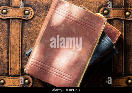 Alte Vintage-Antiquarbücher auf einem Vintage-Lederkoffer. Vintage-Reise-Hintergrund-Konzept. Stockfoto