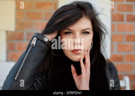 Porträt eines Mädchens in der Stadt. Wunderschöne Brünette in den Straßen der Stadt. Stilvolle Frau reist durch die Städte Europas. Meine Dame Stockfoto