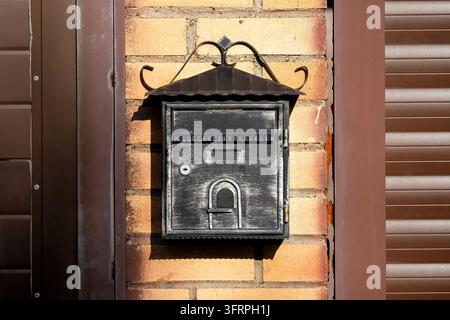 Schwarzer Straßensbriefkasten. Schöner Briefkasten für Briefe und Zeitungen Stockfoto