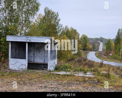 Kleine, baufällige Bushaltestellenhütte mit einem Schild an der Seite. Stockfoto
