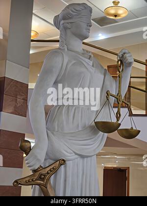 Moskau - 24. Okt. 2024: Statue einer Frau, die Waagen in einem Justizgericht hält. Die Statue ist weiß und golden Stockfoto