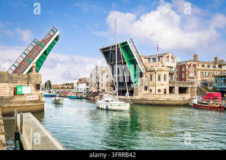 Weymouth Town Bridge, eine Doppelflügelklappbrücke, öffnet sich, um Booten Ein- und Ausfahrt in die Marina im Innenhafen zu ermöglichen. Stockfoto