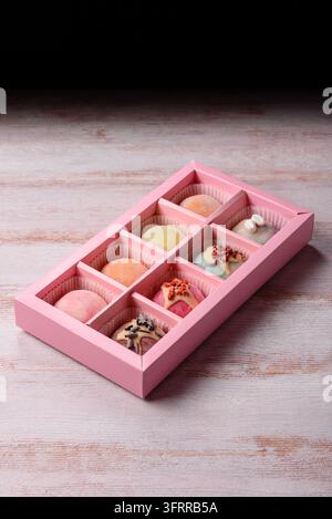 Asiatisches japanisches Mochi-Dessert in verschiedenen Farben und Fruchtgeschmacksrichtungen. Mochi-Dessert als Lebensmittelhintergrund für Ihr Design Stockfoto