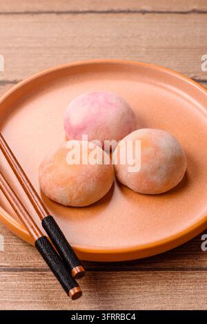 Asiatisches japanisches Mochi-Dessert in verschiedenen Farben und Fruchtgeschmacksrichtungen. Mochi-Dessert als Lebensmittelhintergrund für Ihr Design Stockfoto