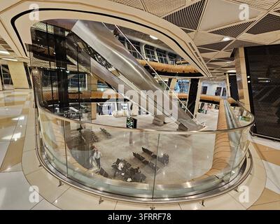 BAKU - 11. JAN, 2025: Ein Einkaufszentrum mit Glaswänden, das über Rolltreppen und ein gläsernes Atrium verfügt. Das Einkaufszentrum ist leer und die Rolltreppen werden nicht benutzt Stockfoto