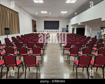 Moskau - 20. Feb 2025: Ein großes Auditorium mit Reihen roter Stühle. Die Stühle sind leer und der Raum ist schwach beleuchtet Stockfoto