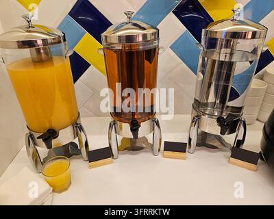 Drei Krüge mit Saft und Wasser stehen auf einem Tisch. Es gibt auch eine Tasse Orangensaft auf dem Tisch Stockfoto