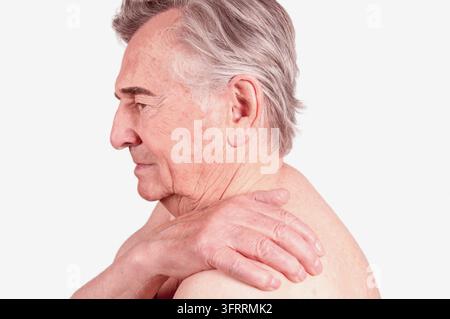 Senior mann hält sich die Schulter wegen Schmerzen Stockfoto