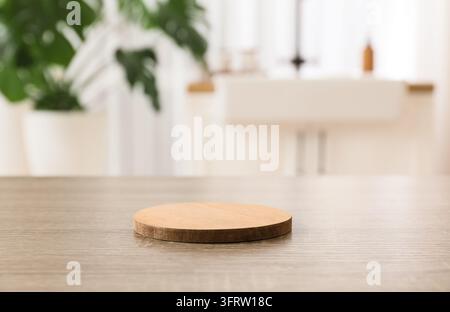 Produktpräsentationspodest, leerer hölzerner runder Stand für Kosmetikbranding und Hautpflegepräsentation vor einem unscharfen Hintergrund eines Wohnraums Stockfoto
