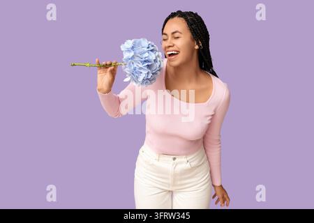 Selbstpflege und Wellness, glückliche junge Frau riecht eine blaue Hortensienblüte mit Freude und Entspannung, positives mentales Wohlbefinden und natürlicher Schönheitskonzept Stockfoto