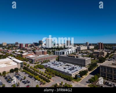 Drohnenaufnahme der Skyline von Columbia, South Carolina, mit Stadttürmen, die über baumgesäumten Straßen und Vierteln aufragen, und Verkehr, der entlang der a Stockfoto
