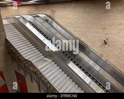 Moderne Metallrolltreppen und Betonstufen in einer unterirdischen öffentlichen Verkehrstation in Montreal, Kanada, mit beigen Ziegelwänden und Ausgangsschild Stockfoto