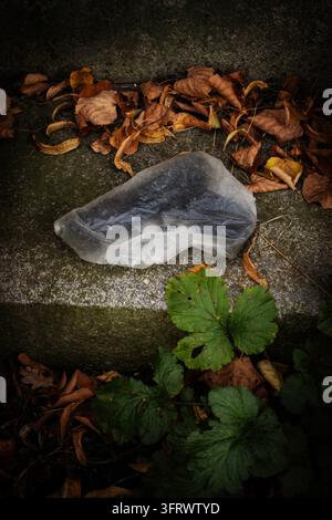 Eine zerknitterte durchsichtige Plastiktüte mit einer darin eingewickelten Pistole Stockfoto