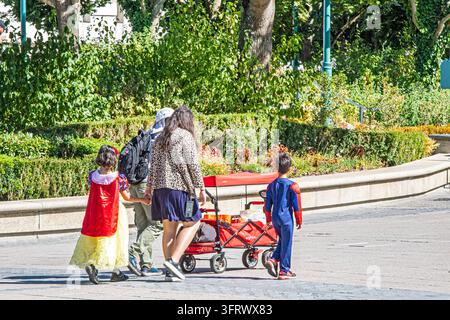 Eine Familie mit Kindern in Kostümen, die an einem sonnigen Tag, dem 20. August 2026, zu einem Kinderunterhaltungszentrum in Paris gehen Stockfoto