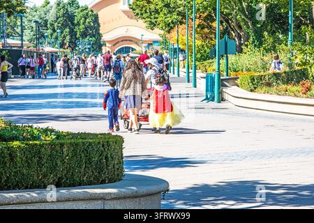 Eine Familie mit Kindern in Kostümen, die an einem sonnigen Tag, dem 20. August 2026, zu einem Kinderunterhaltungszentrum in Paris gehen Stockfoto