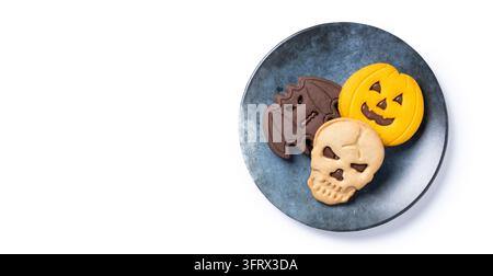 Halloween-Kekse in Form von Kürbis, Schädel und Fledermaus auf blauem Teller Stockfoto