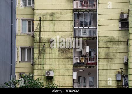 Verwittertes Hausfassade zeigt unsichere Lebensbedingungen, Wasserstau und Rost aufgrund von Feuchtigkeit. Stockfoto