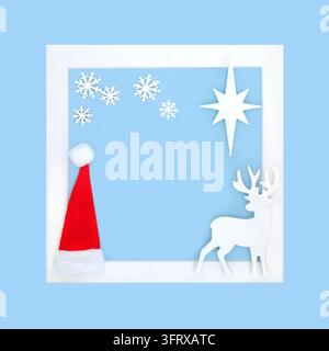 Weihnachtsrahmen Nordpol-Konzept, Rentier, Weihnachtsmannmütze, Schneeflocke, Sternverzierungen auf blauem Hintergrundrahmen, weißer Rahmen. Festliche Grußkarte. Stockfoto