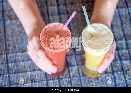 Frau Hände halten zwei Gläser mit Ananas und Wassermelone frischen Saft, Nahaufnahme, gesunden Lebensstil Konzept Stockfoto