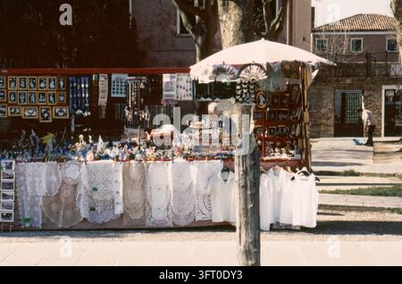 Ein Stand, der typische Souvenirs (traditionelle Spitze, Handarbeiten von der benachbarten Insel Murano) auf der Insel Burano verkauft. Lagune von Venedig, Italien, Februar 1981 Stockfoto