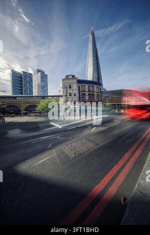 Blick auf The Shard, das über einer historischen Kneipe und modernen Gebäuden aufragt, mit einem roten Bus, der an einem sonnigen Tag in London, England, Vereinigtes Königreich, vorbeifährt Stockfoto