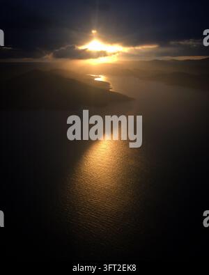 Sonnenuntergang über der Adria in der Nähe der kroatischen Küste, Mai 2018. Das Bild fängt das Licht ein, das durch die Wolken bricht und einen goldenen Reflex auf dem Stockfoto