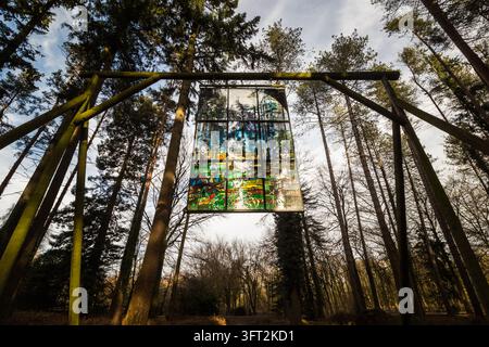 Kathedrales Buntglas-Kunstwerk, das zwischen hohen Bäumen auf dem Forest of Dean Sculpture Trail in Coleford, Gloucestershire, England aufgehängt ist Stockfoto