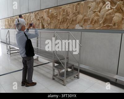 ATHEN, GRIECHENLAND - 16. MAI 2025 - Parthenon - Reiser mit mittlerem Alter fotografiert antike Parthenon-Marmorartefakte an der historischen Stätte in Athen Stockfoto