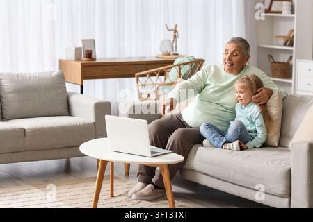 Intergenerationale Verbindung und digitale Inklusion, Großmutter und Enkelin nutzen gemeinsam einen Laptop zu Hause für Videoanrufe oder Online-Lernen Stockfoto